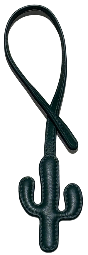 A dark green leather luggage tag shaped like a cactus, featuring a stitched leather loop at the top, shown against a plain white background.